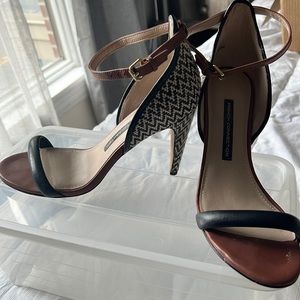 brown sandals with black leather details and black and cream colored heel